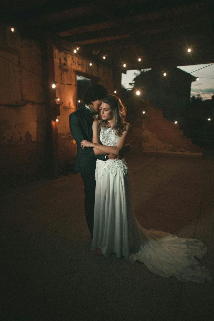 pexels-photo-2111255-2111255 Captivating image of a bride and groom embracing under romantic lighting at their wedding.